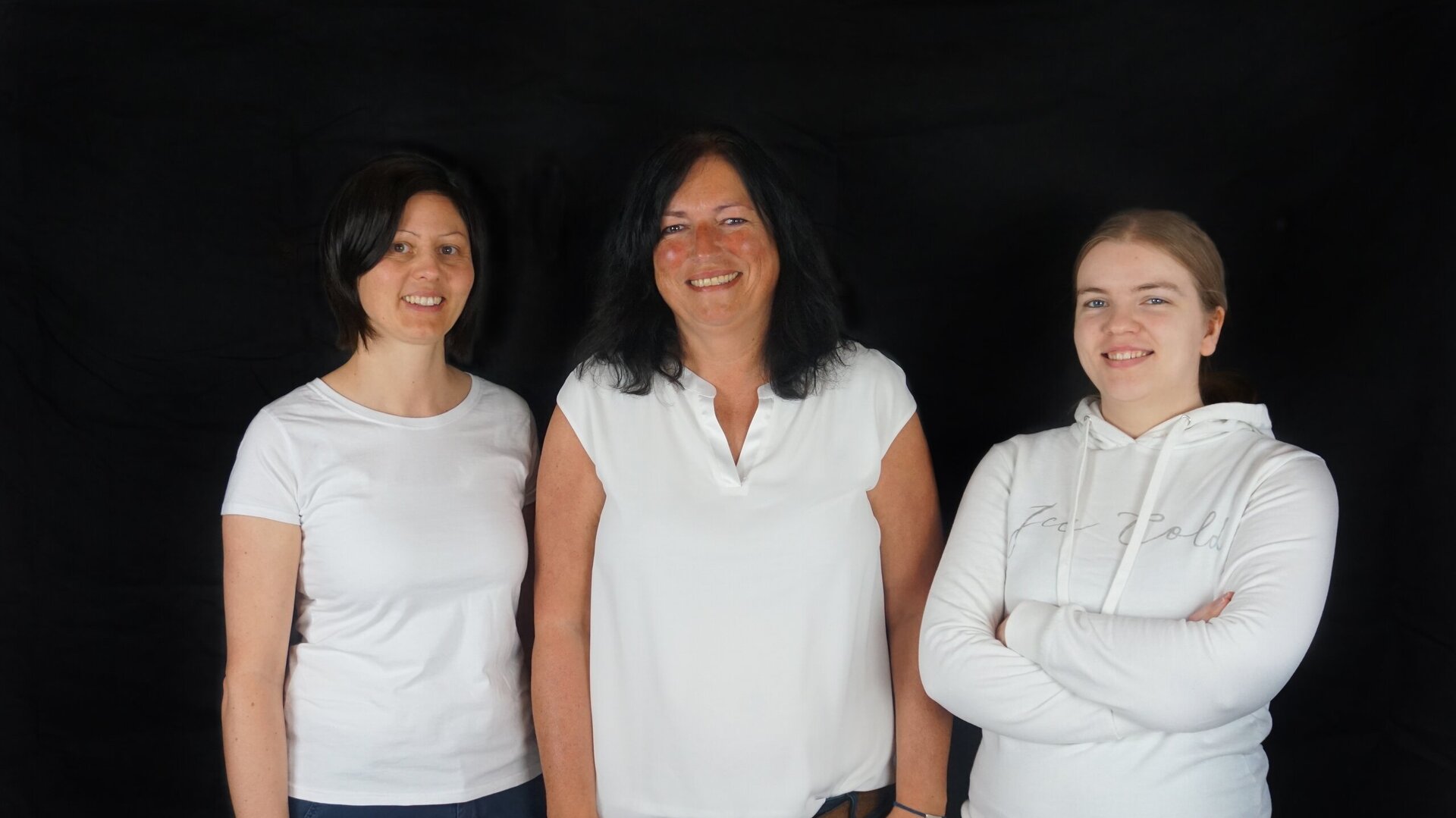 Gruppenfoto vor schwarzem Hintergrund