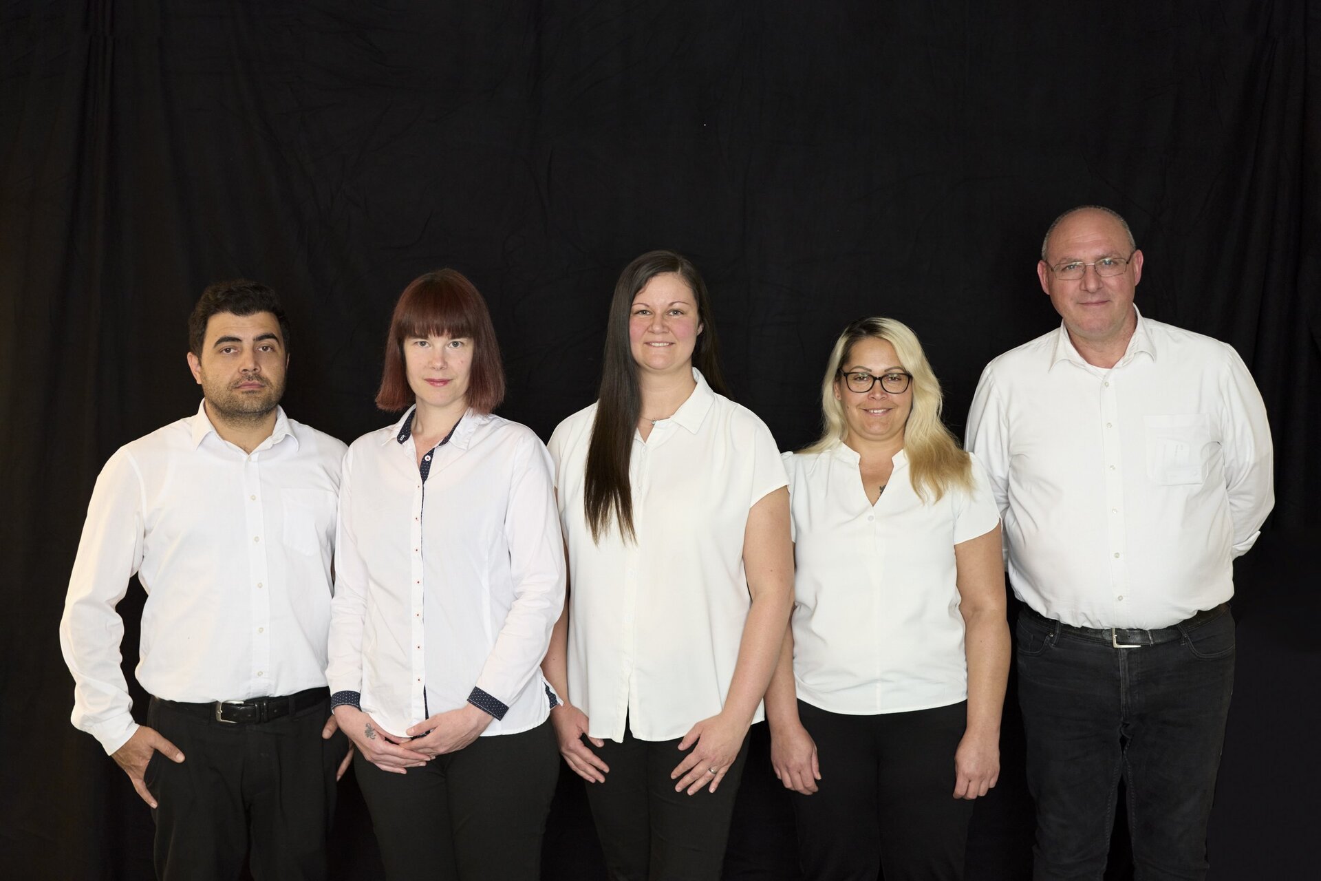 Gruppenfoto vor schwarzem Hintergrund