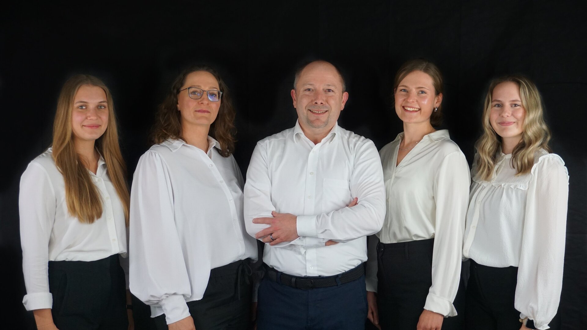 Gruppenfoto vor schwarzem Hintergrund