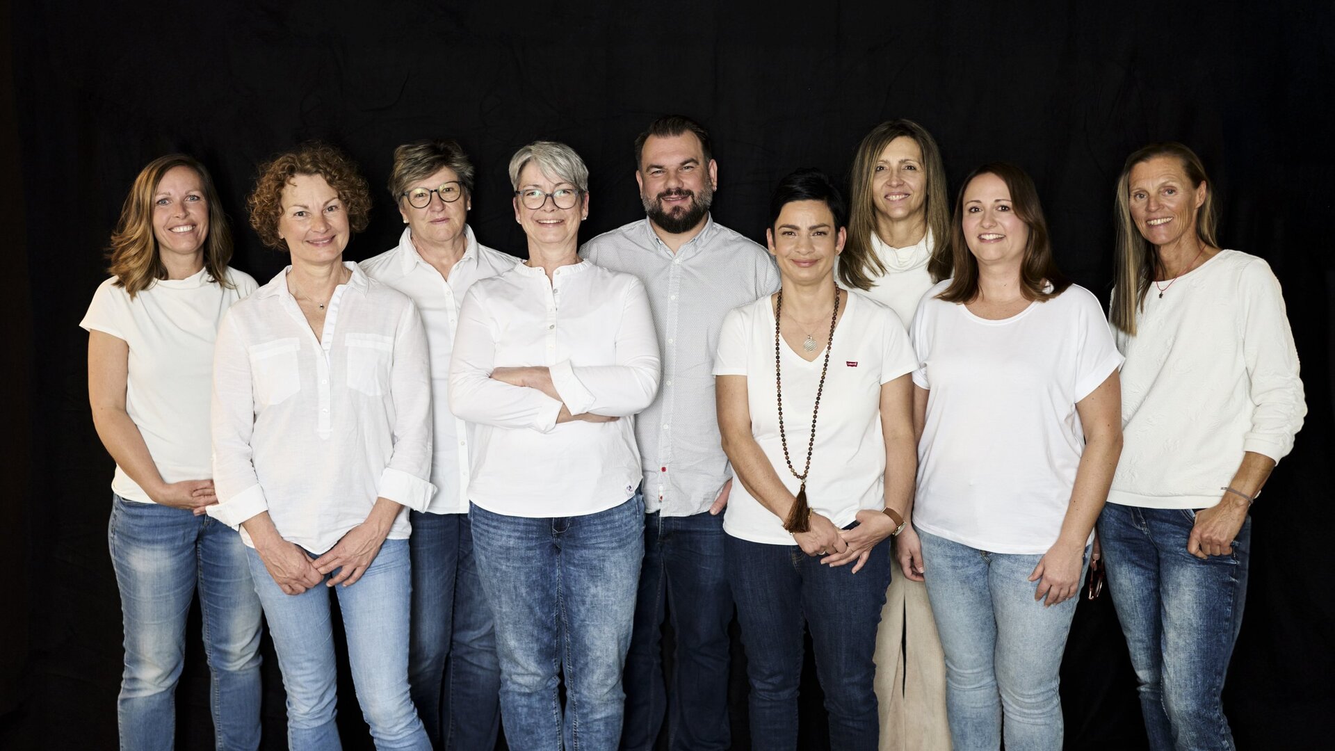 Gruppenfoto vor schwarzem Hintergrund