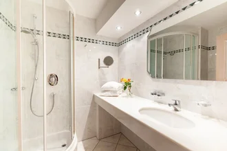 Beispielzimmer mit Bett, TV und Schreibtisch