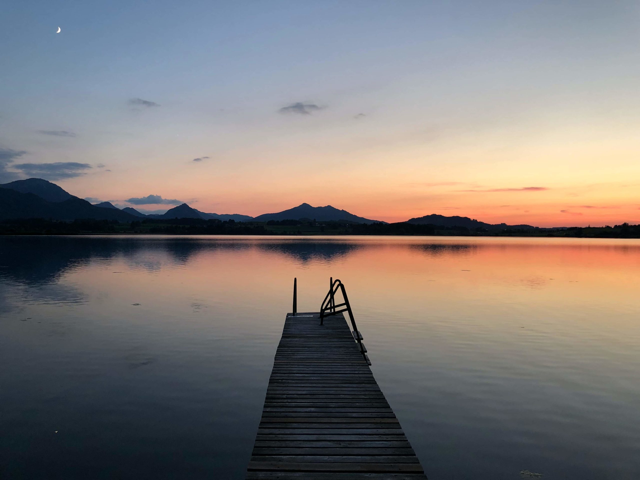 Abendstimmung: Sonnenuntergang am See mit Blick über einen Steeg